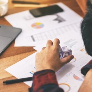 A businessman working with feeling frustrated and stressed with screwed up papers
