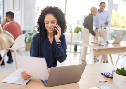 Black woman, phone call and laptop with paper in office for communication and information. Happy en