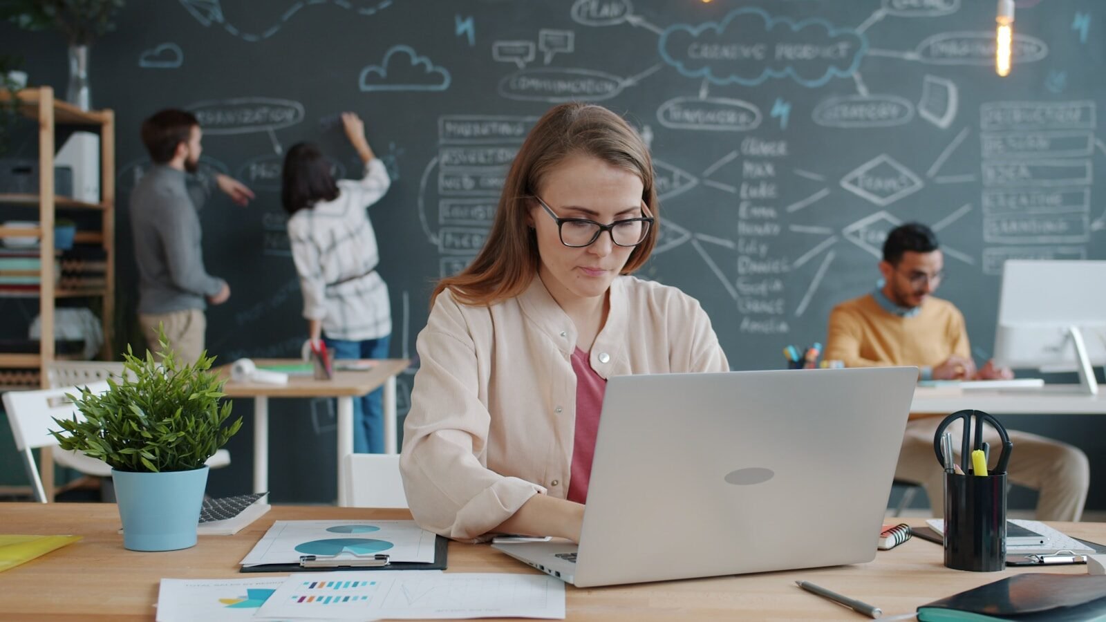 start-ups Woman working on laptop in busy modern office