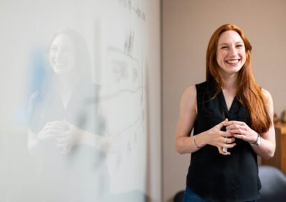 business smiling woman presenting at whiteboard