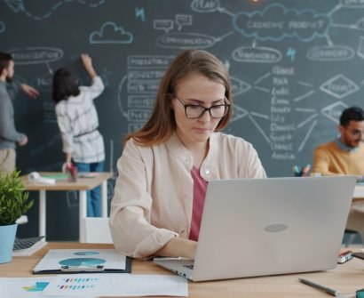 start-ups Woman working on laptop in busy modern office